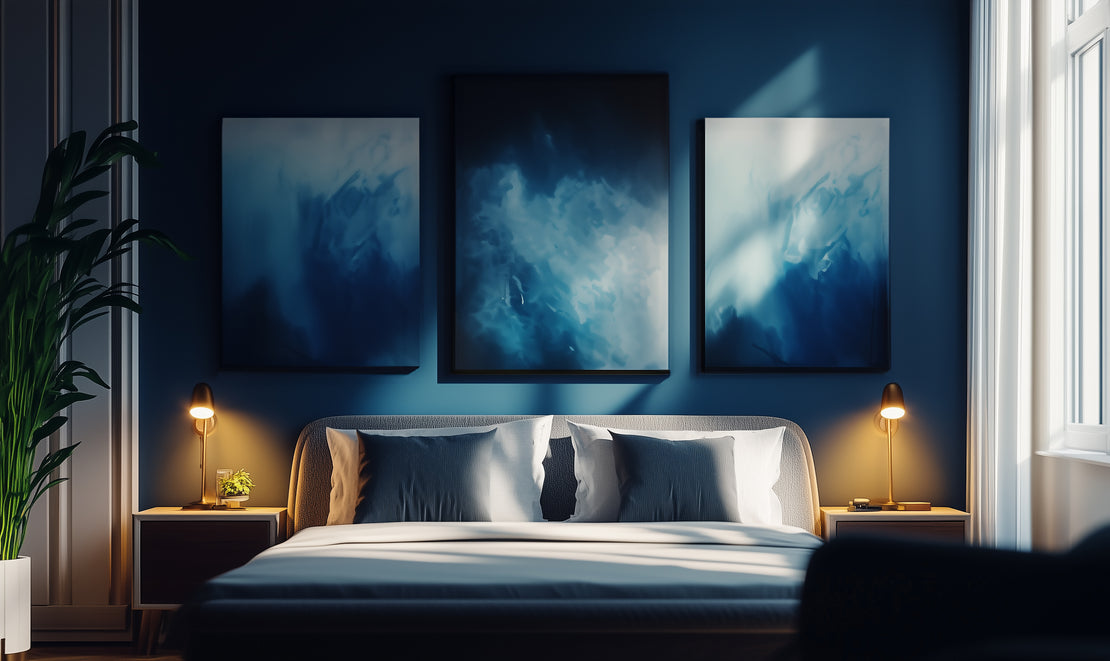 Three custom canvas art pieces hang on the wall above a hotel bed